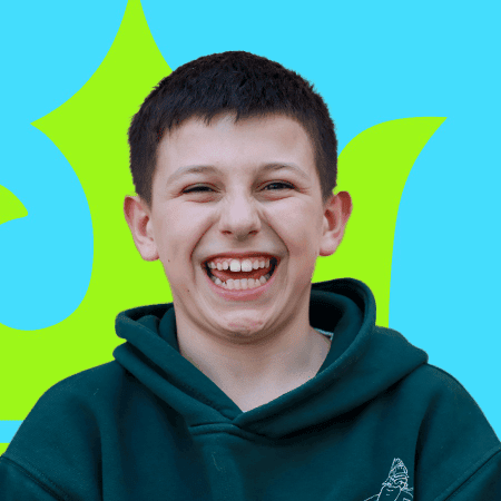 Joven sonriendo en entorno colorido, promoviendo educación internacional y oportunidades para estudiantes jóvenes.